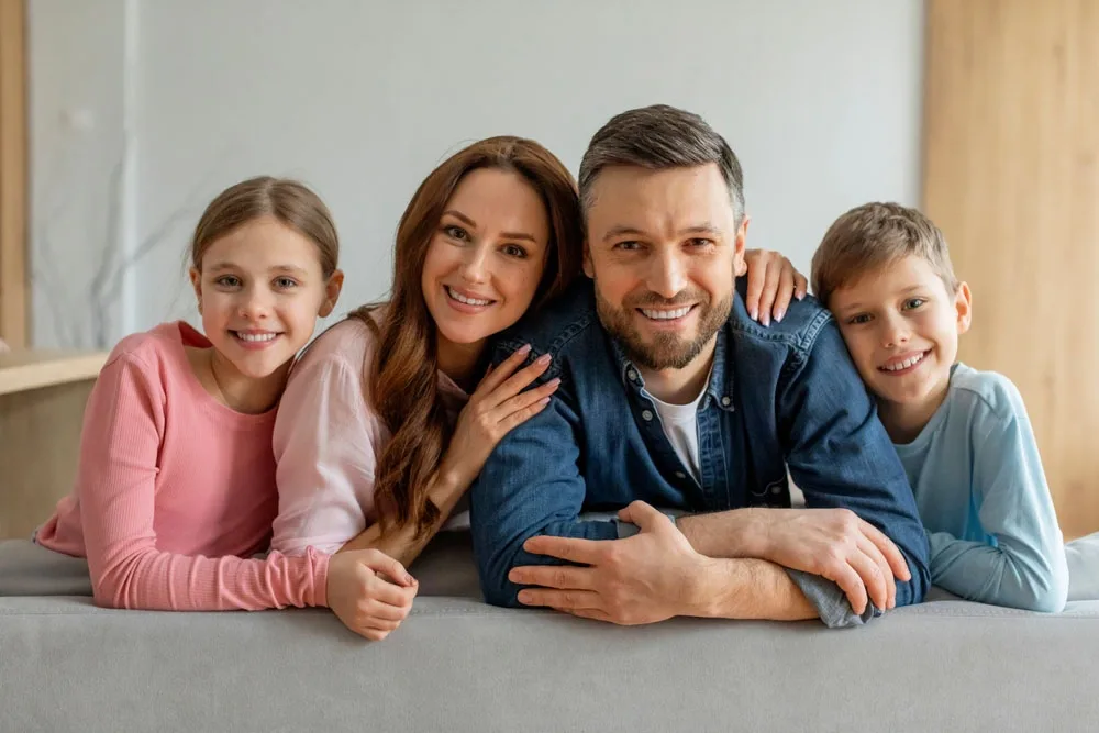 Three generations of a family smiling together indoors