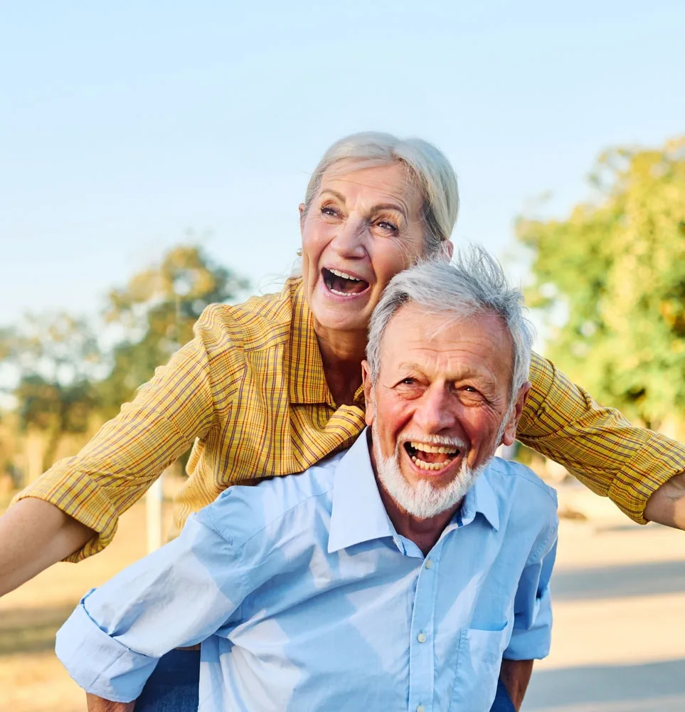 Dental Implants Woodstock Father giving his son a piggyback ride outdoors