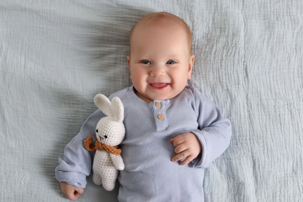 Dentures in Woodstock Baby smiling while holding a toy